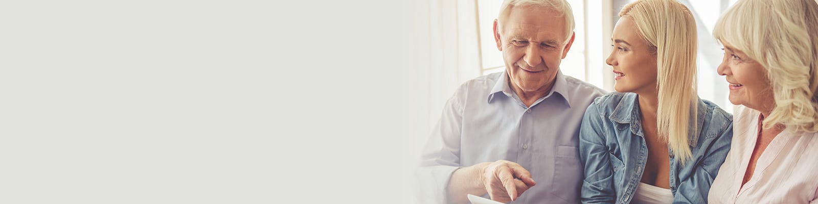 a granddaughter showing her parents how to use a tablet computer